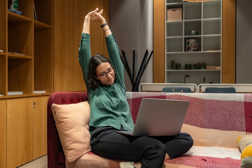 femme qui s'étire en faisant une pause devant son ordinateur
