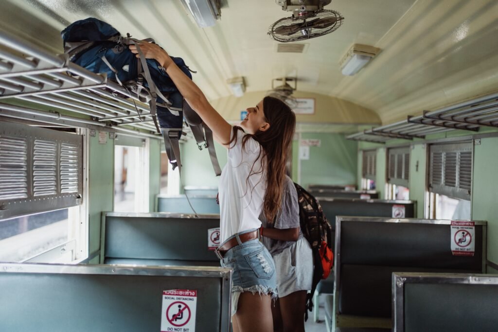 femme qui voyage seule et qui met son sac dans le compartiment bagage du train