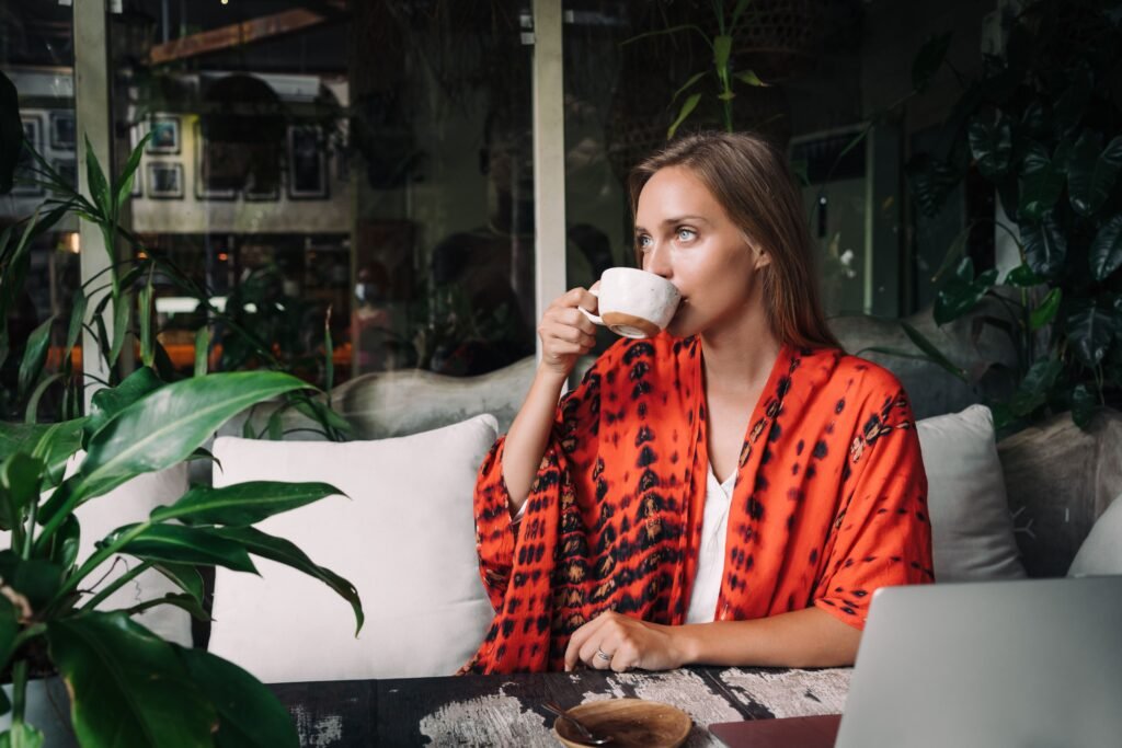 femme qui profite de son temps seule pour boire un café en terrasse 