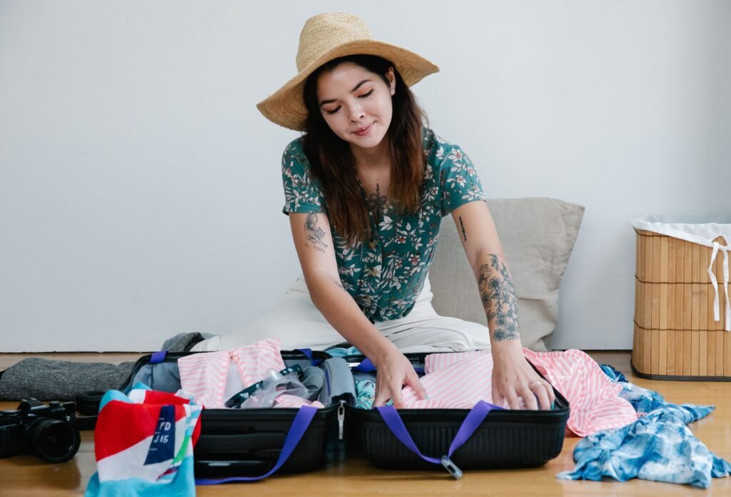 femme qui est en train de préparer sa valise avant de partir en voyage